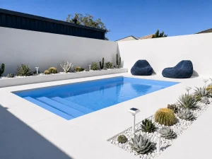 Bermuda Blue Sparkle fibreglass pool in a modern white courtyard with cactus landscaping and bright blue water.
